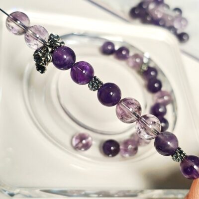 Hand-stringing the amethyst crystal bracelet on elastic cord, with Thai silver spacers and sakura bead cap