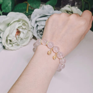 Angled view of rose quartz bracelet highlighting the soft pink tones