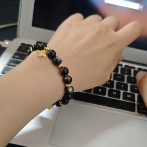 Silver obsidian bracelet with four-leaf clover worn on wrist