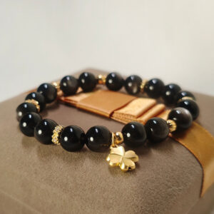 Display view of silver obsidian bracelet with delicate four-leaf clover detail