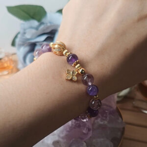 Woman wearing an amethyst lucky clover bracelet for calm, protection, and everyday good fortune.