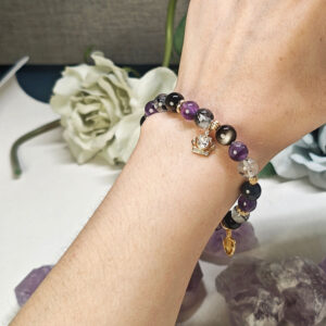 Hand wearing crown feather guardian bracelet with Amethyst, Silver Obsidian, and Black Rutilated Quartz for everyday wear