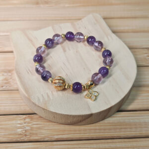 Close-up of the four-leaf clover charm and natural amethyst beads representing luck, blessings, and positive energy.