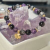Main image of the Four-Leaf Clover Protection Bracelet featuring amethyst, silver obsidian, black rutilated quartz, and a four-leaf clover charm