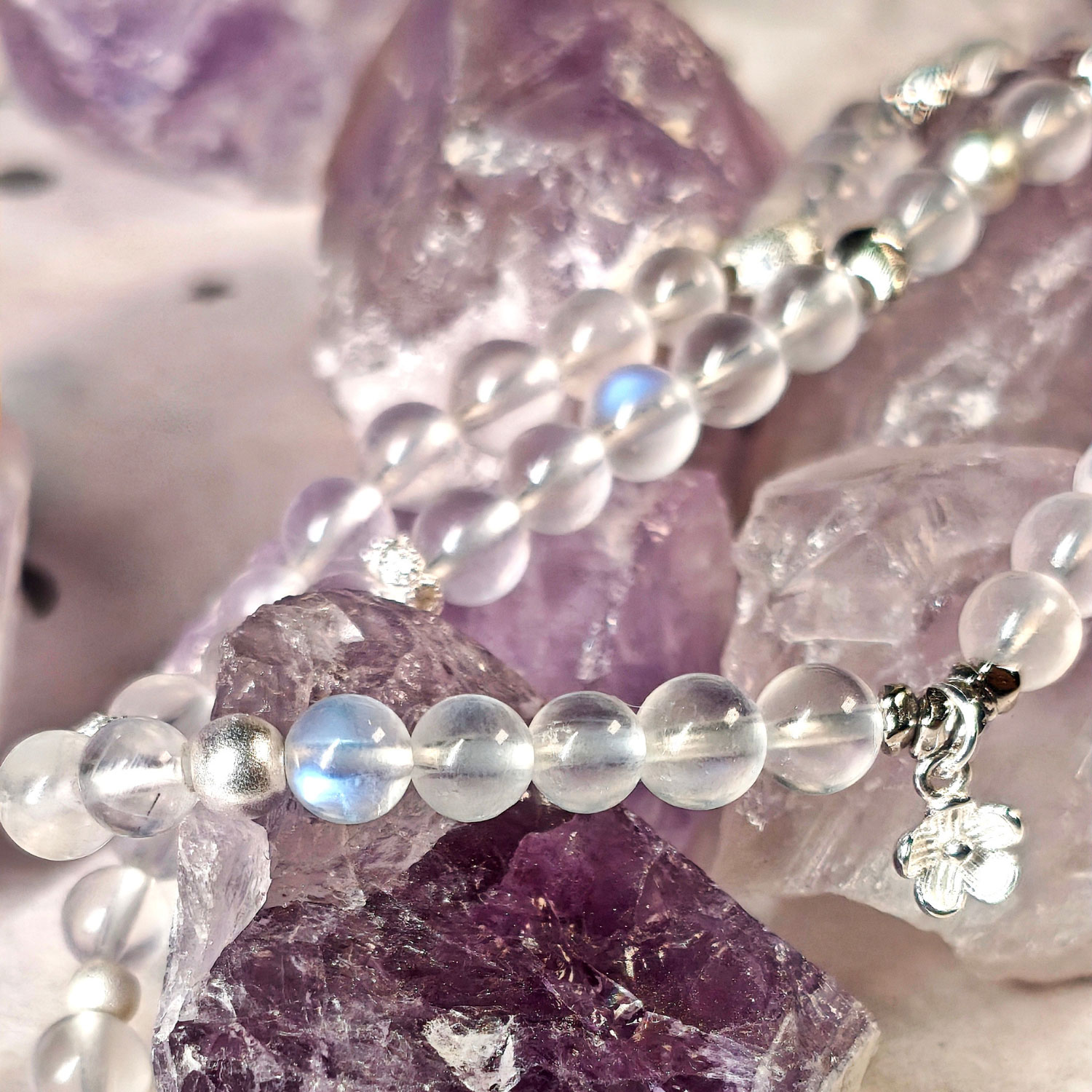 Close-up of natural Blue Moonstone beads with blue adularescence and genuine 925 sterling silver platinum-plated details.