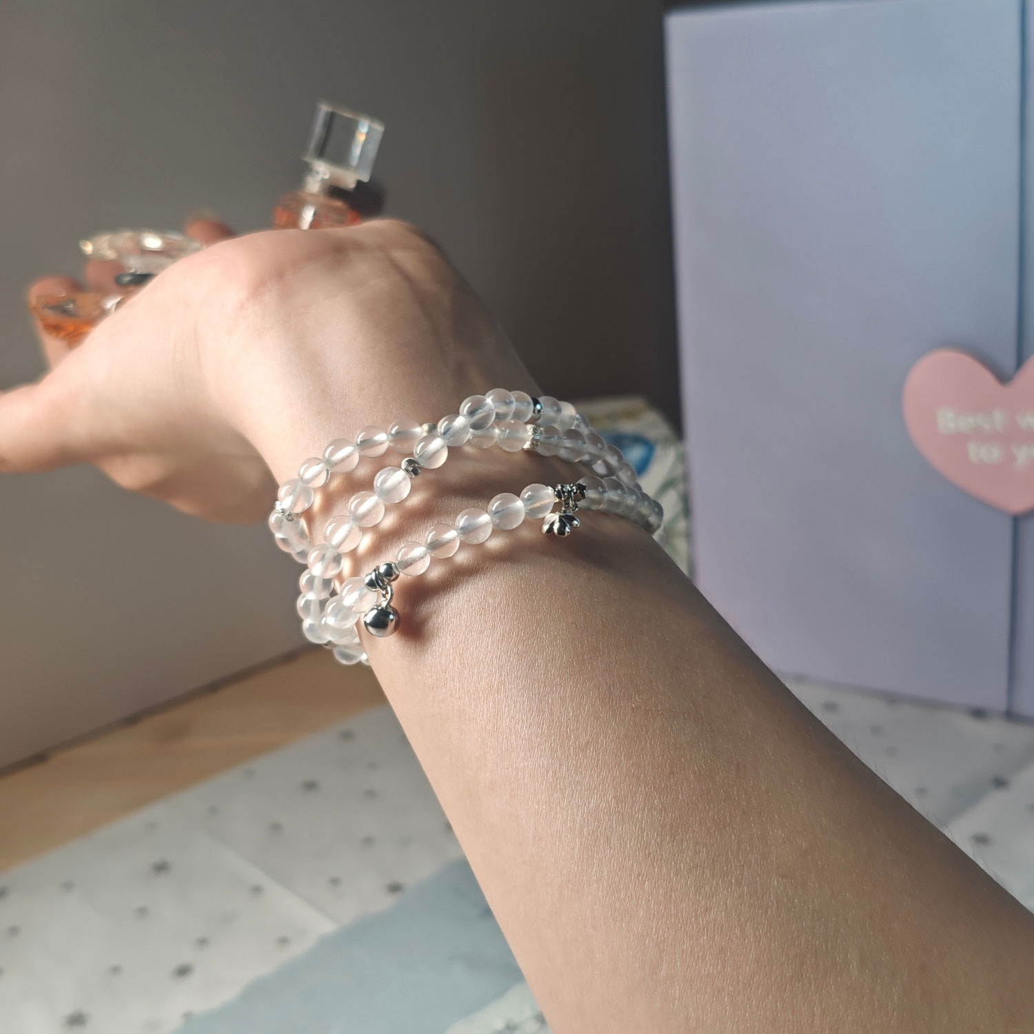 Woman wearing a handcrafted Blue Moonstone triple wrap bracelet with genuine 925 sterling silver for an elegant layered everyday look.