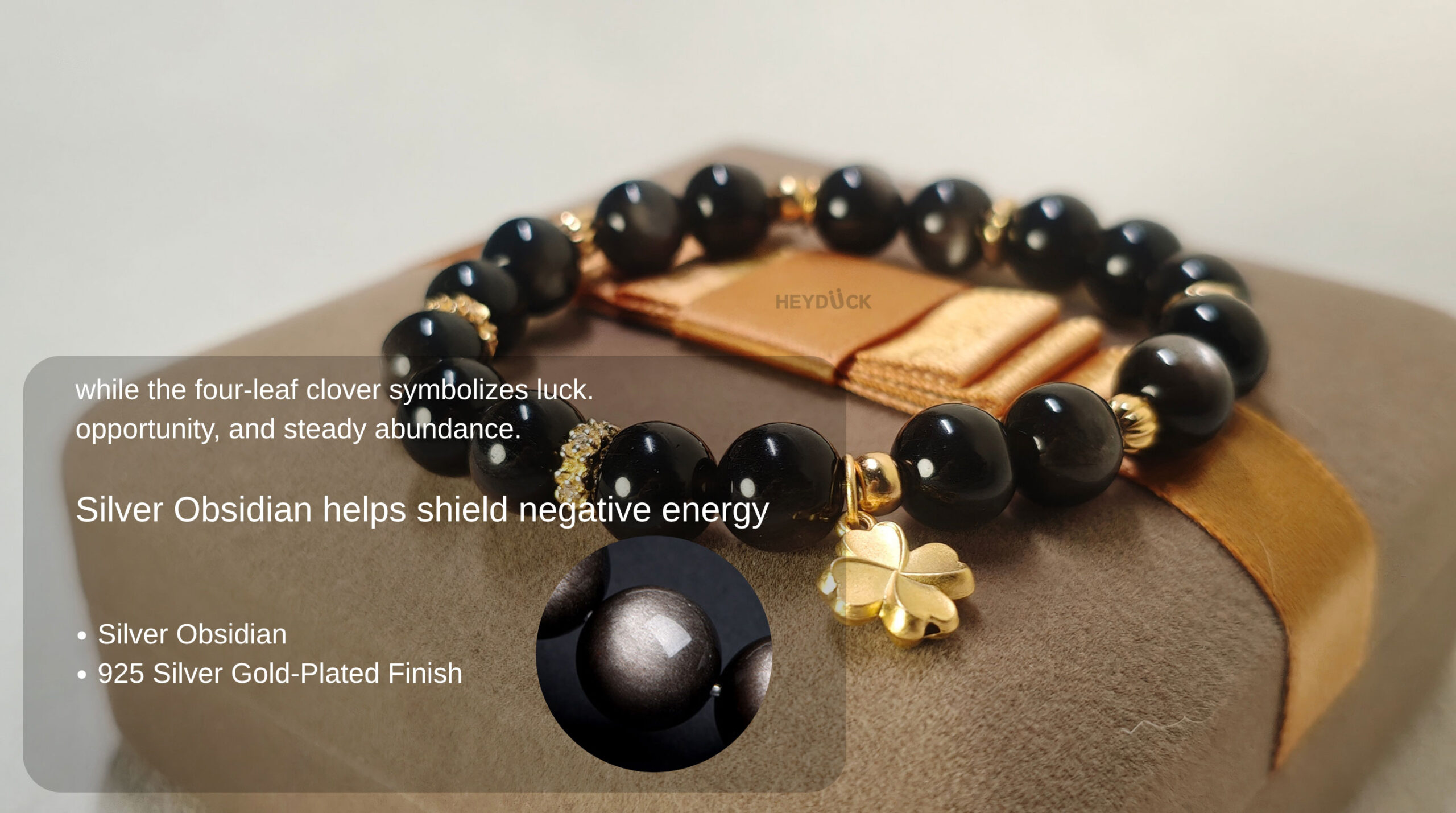 Natural Silver Obsidian bracelet with a four-leaf clover charm representing protection, luck, and abundance