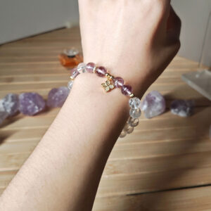 Woman wearing Ice Lavender Quartz Clarity Bracelet with Clear Quartz and four-leaf clover charm