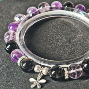 Close-up detail of Midnight Bloom bracelet showing natural amethyst, silver obsidian beads, Ice Lavender Quartz, and 925 silver flower charm.