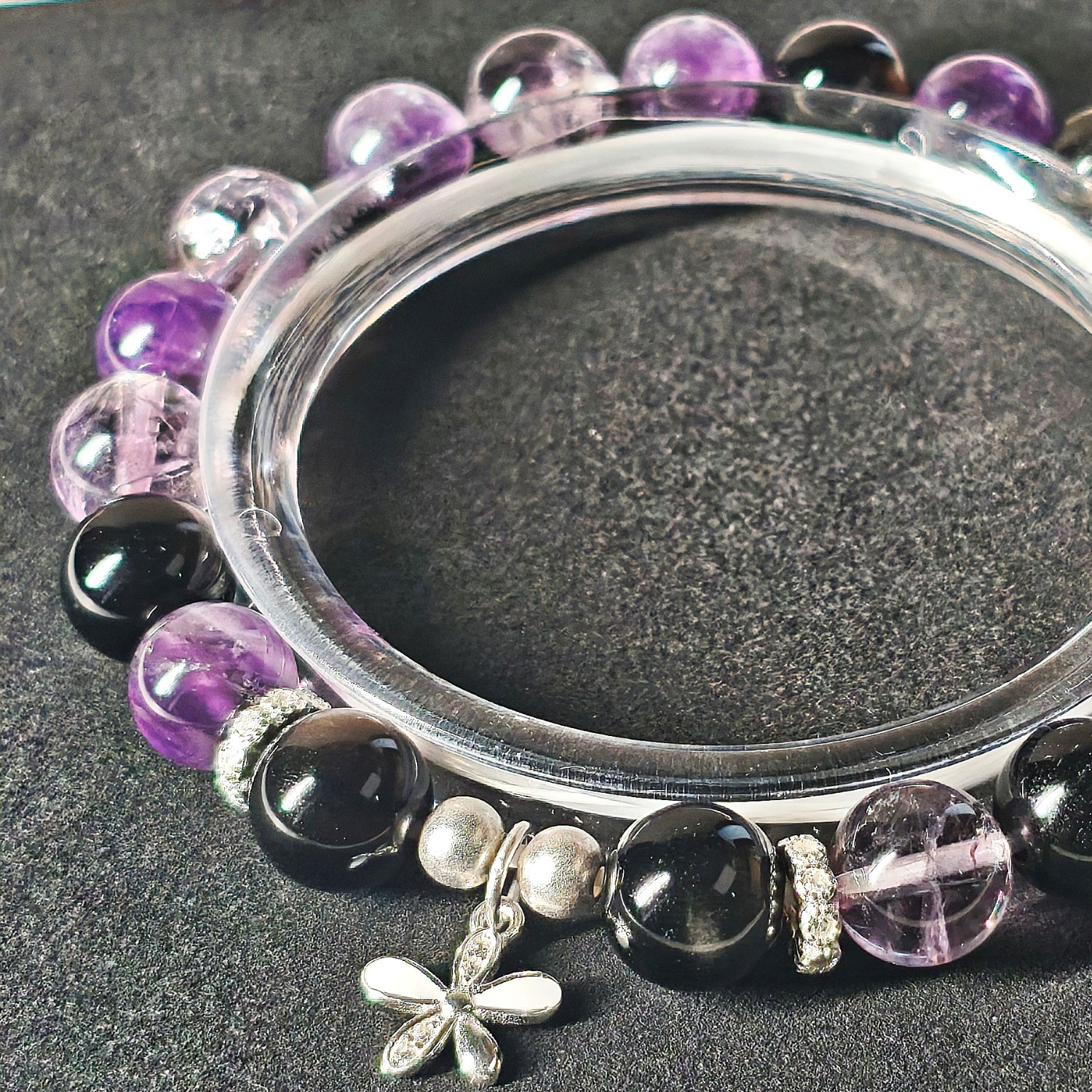 Close-up detail of Midnight Bloom bracelet showing natural amethyst, silver obsidian beads, Ice Lavender Quartz, and 925 silver flower charm.