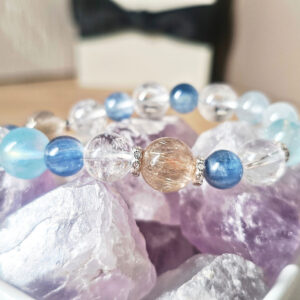 Close-up of AuroraGain CL Veil Crystal Bracelet showing gold rutilated quartz, aquamarine, natural kyanite, blue rutilated quartz, and ice clear quartz