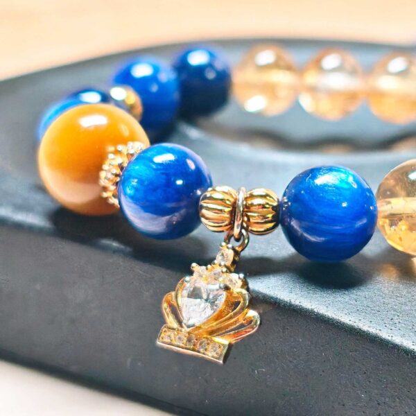 Detailed view of the gold-plated crown charm and 925 sterling silver spacers on CrownReign CL