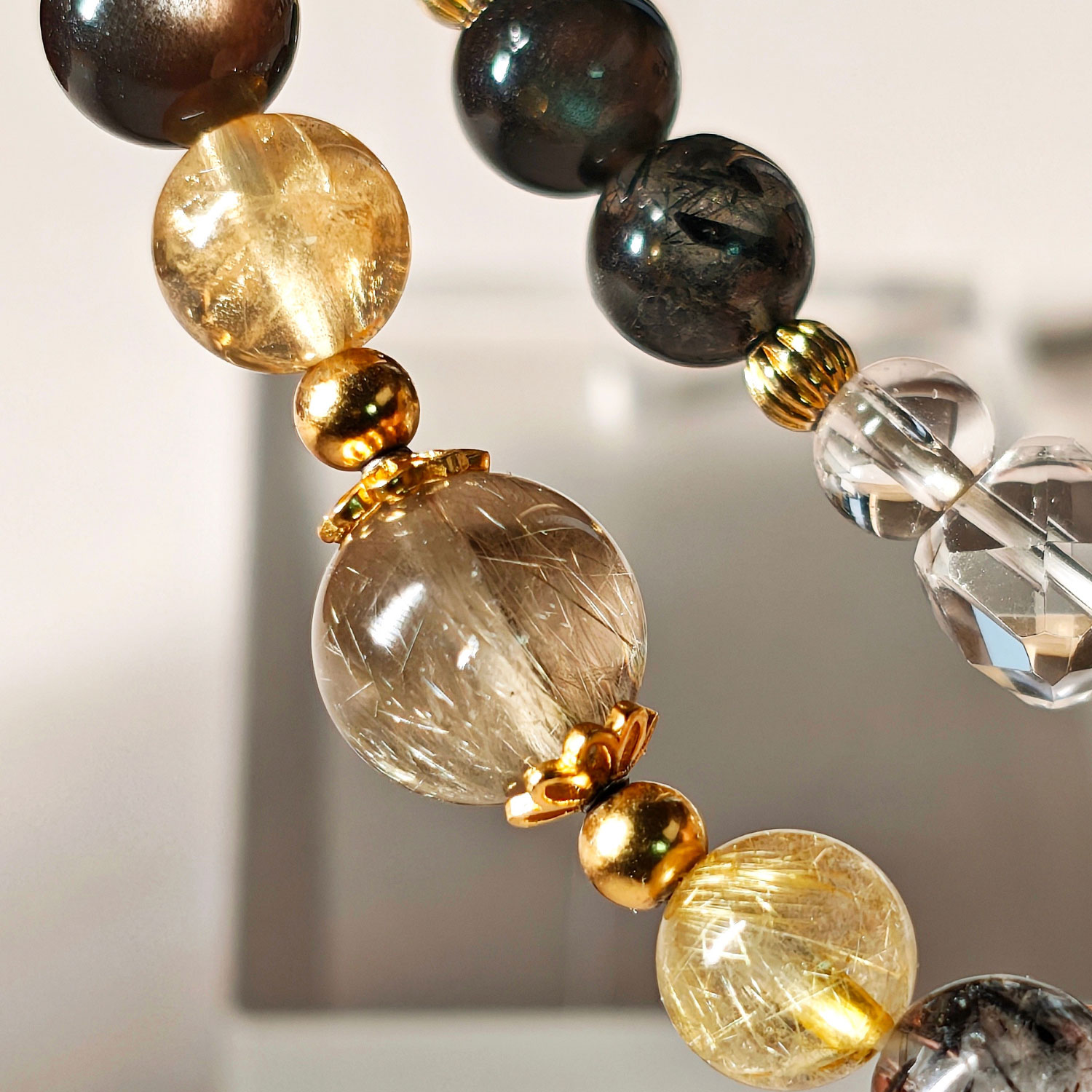Close-up of Golden Aegis Crystal Bracelet showing golden rutilated quartz, ice citrine, and silver obsidian