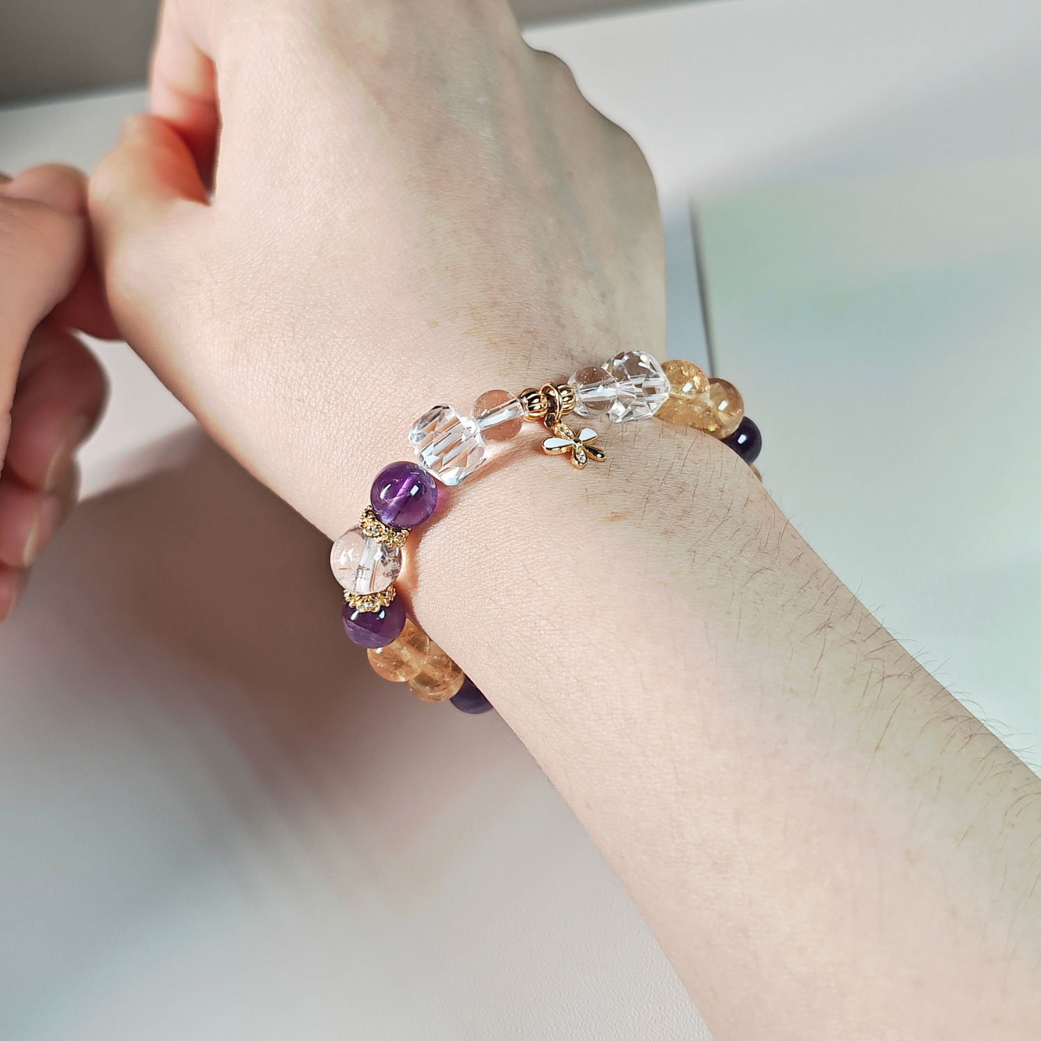 Woman wearing GoldBloom CL Ice Citrine and Amethyst bracelet with an elegant everyday crystal jewelry style