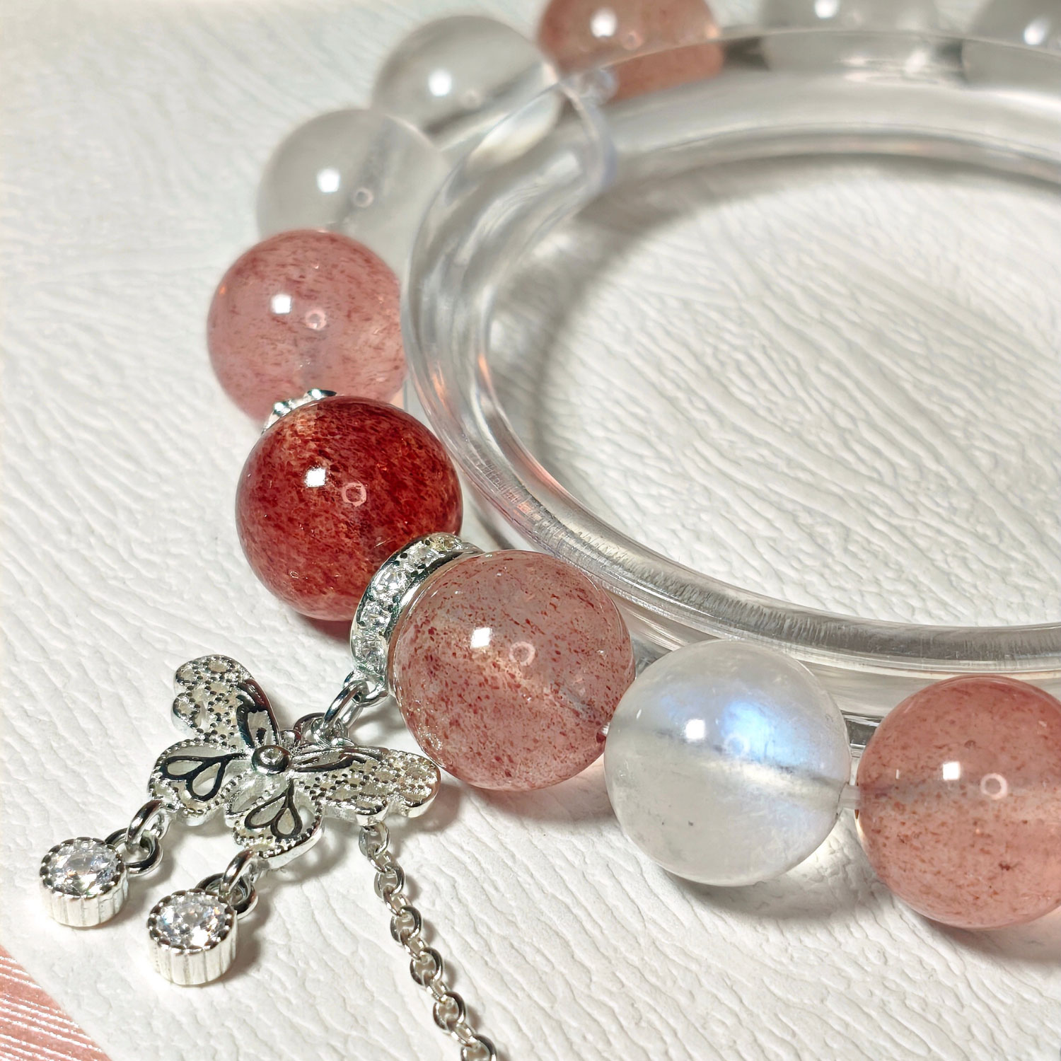 Close-up detail of natural Strawberry Quartz, Blue Moonstone, 925 sterling silver spacers, and butterfly charm