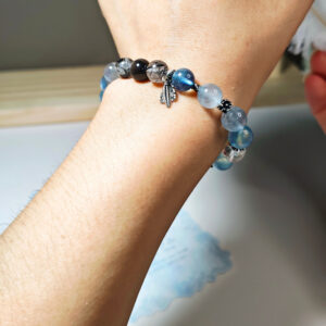 Woman wearing the SkyFlow CL aquamarine crystal bracelet as an elegant accessory for mindful everyday style