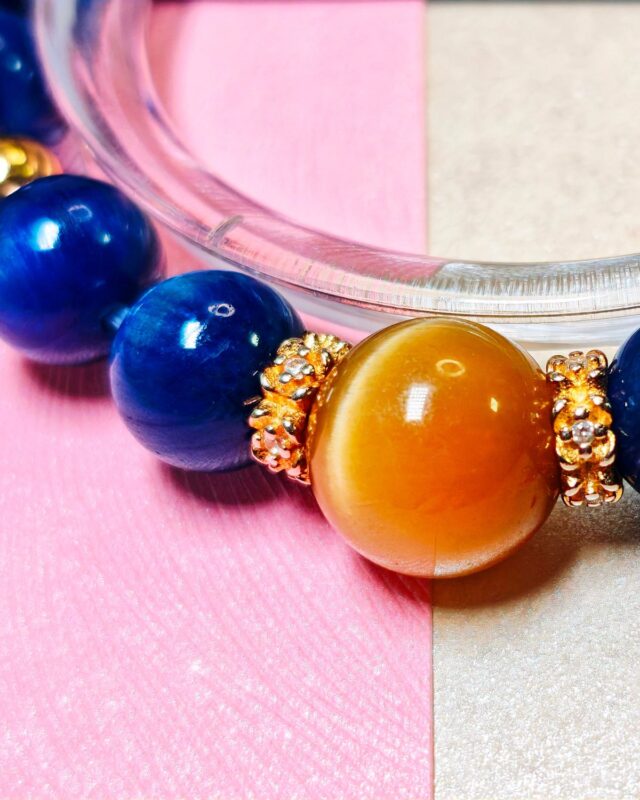 Close view of the gold tiger's eye bead between gold-tone spacer beads and blue kyanite