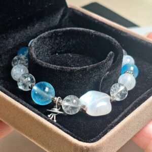 Bracelet standing on a clear display ring inside a gift box, blue moonstone and aquamarine beads in view
