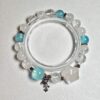 Blue moonstone aquamarine clear quartz bracelet in a full circle seen from above, planet charm at the bottom and one star-shaped moonstone at the lower right