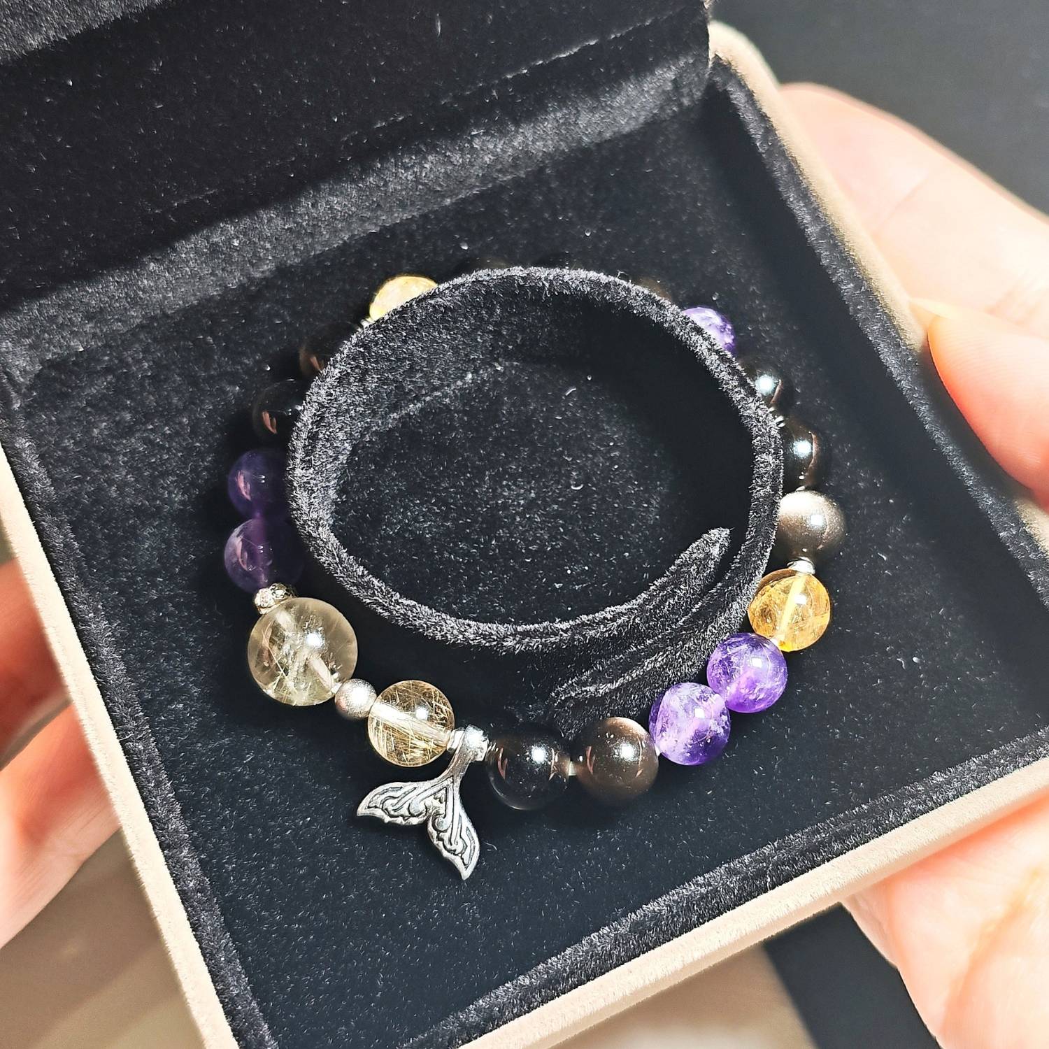 Rising Current crystal bracelet resting inside its black velvet gift box.