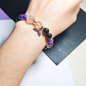 Mermaid tail crystal bracelet worn on the wrist, with the amethyst, Ice Citrine and golden rutilated quartz beads in view.