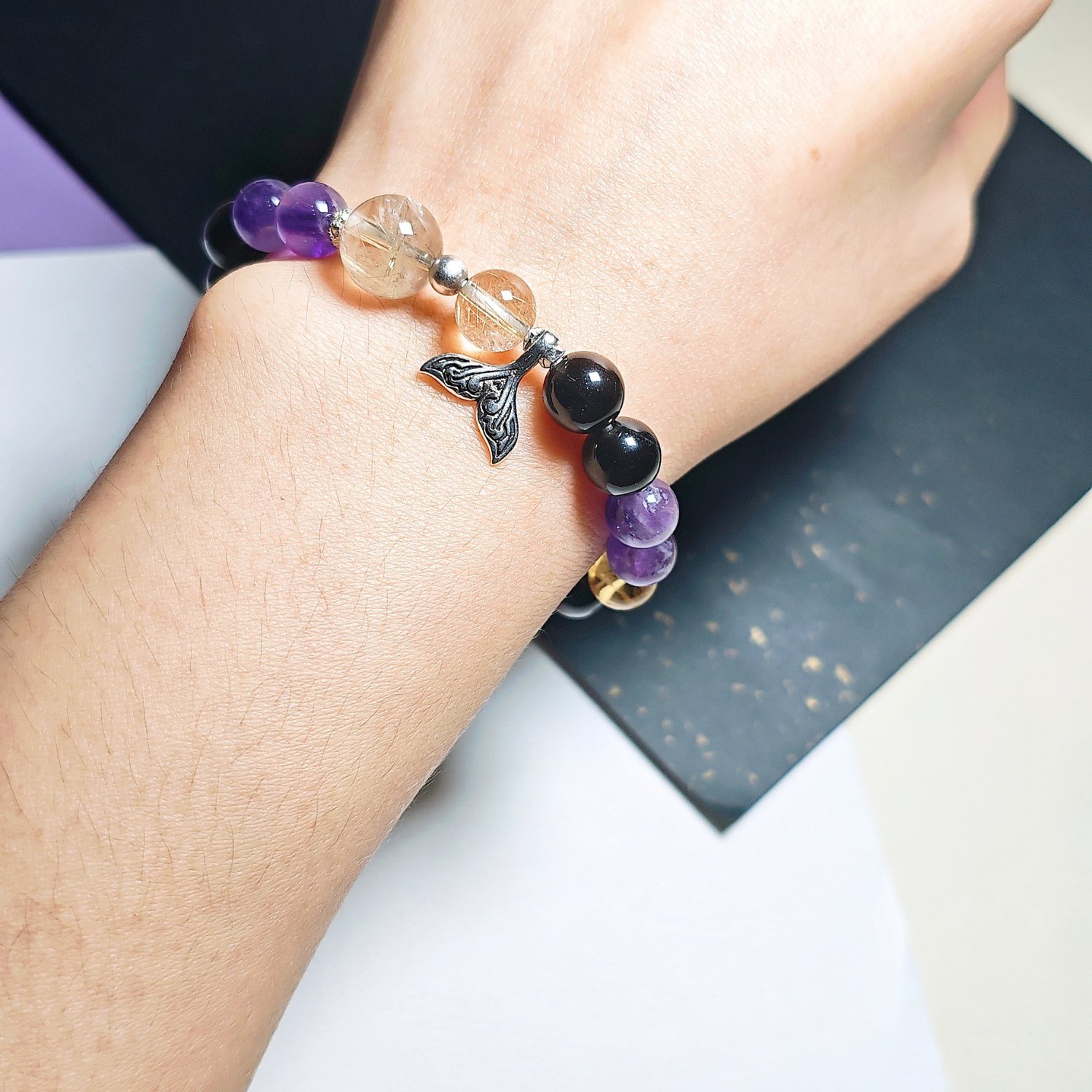 Mermaid tail crystal bracelet worn on the wrist, with the amethyst, Ice Citrine and golden rutilated quartz beads in view.
