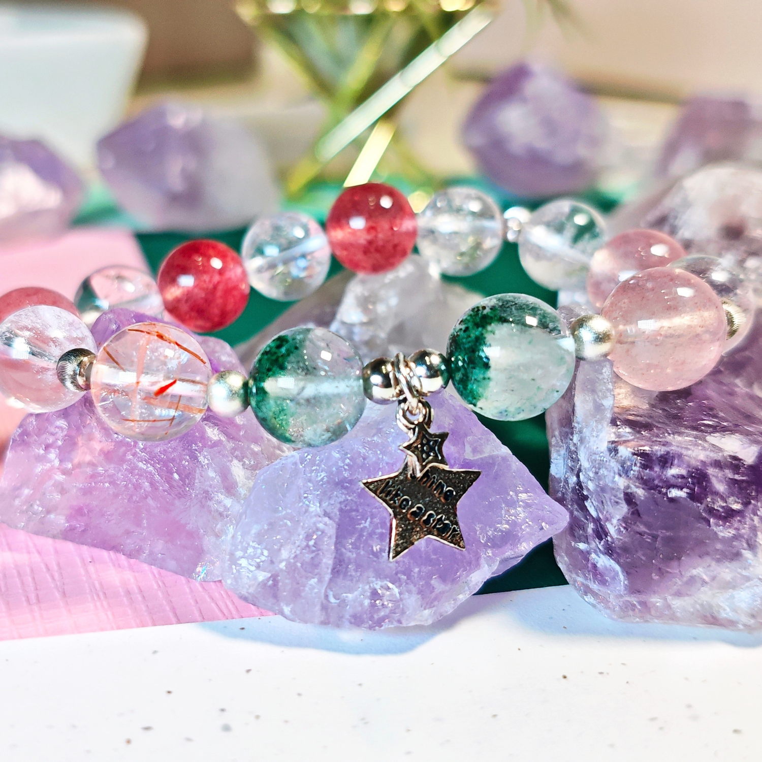 Black gold super seven bracelet worn on the wrist, with the green phantom quartz and ice strawberry quartz beads in view.