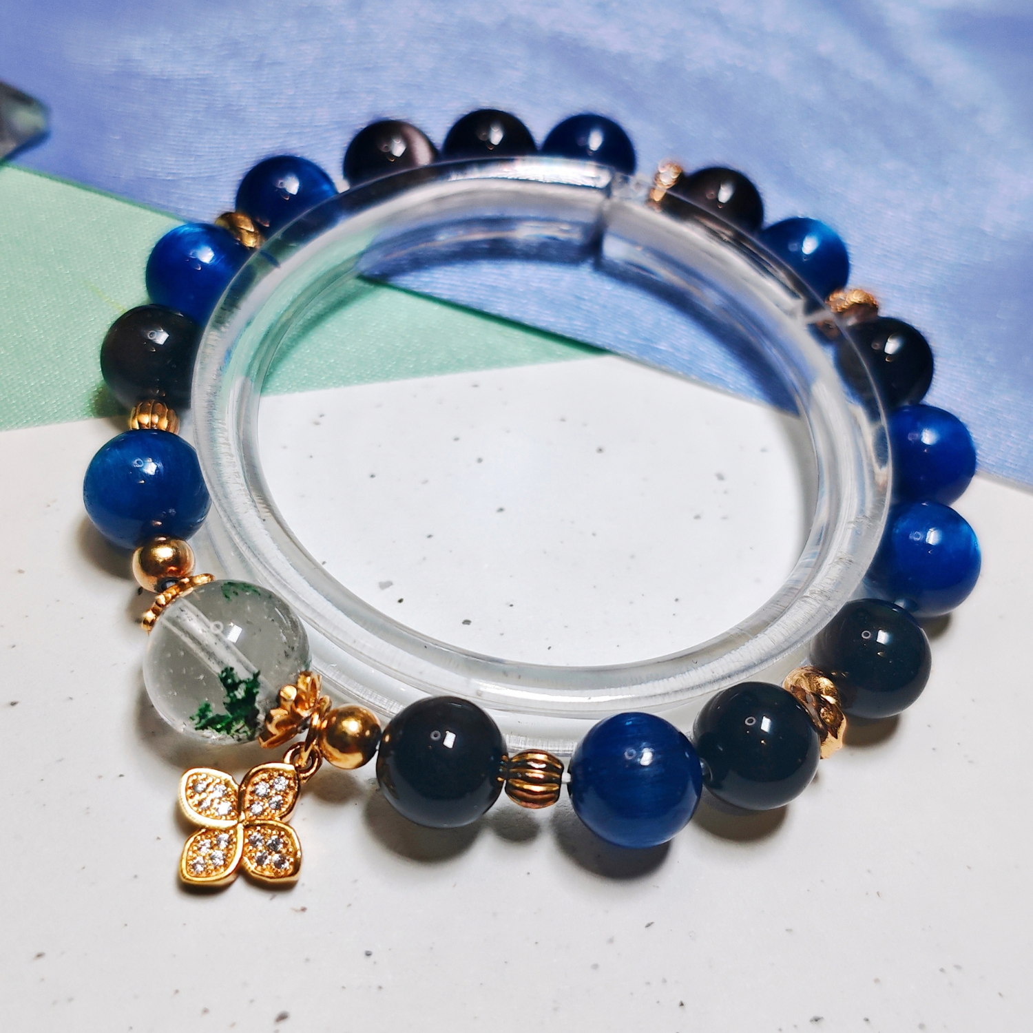 Steady Presence crystal bracelet shown full circle, with its gold-toned four-leaf clover charm at the front.