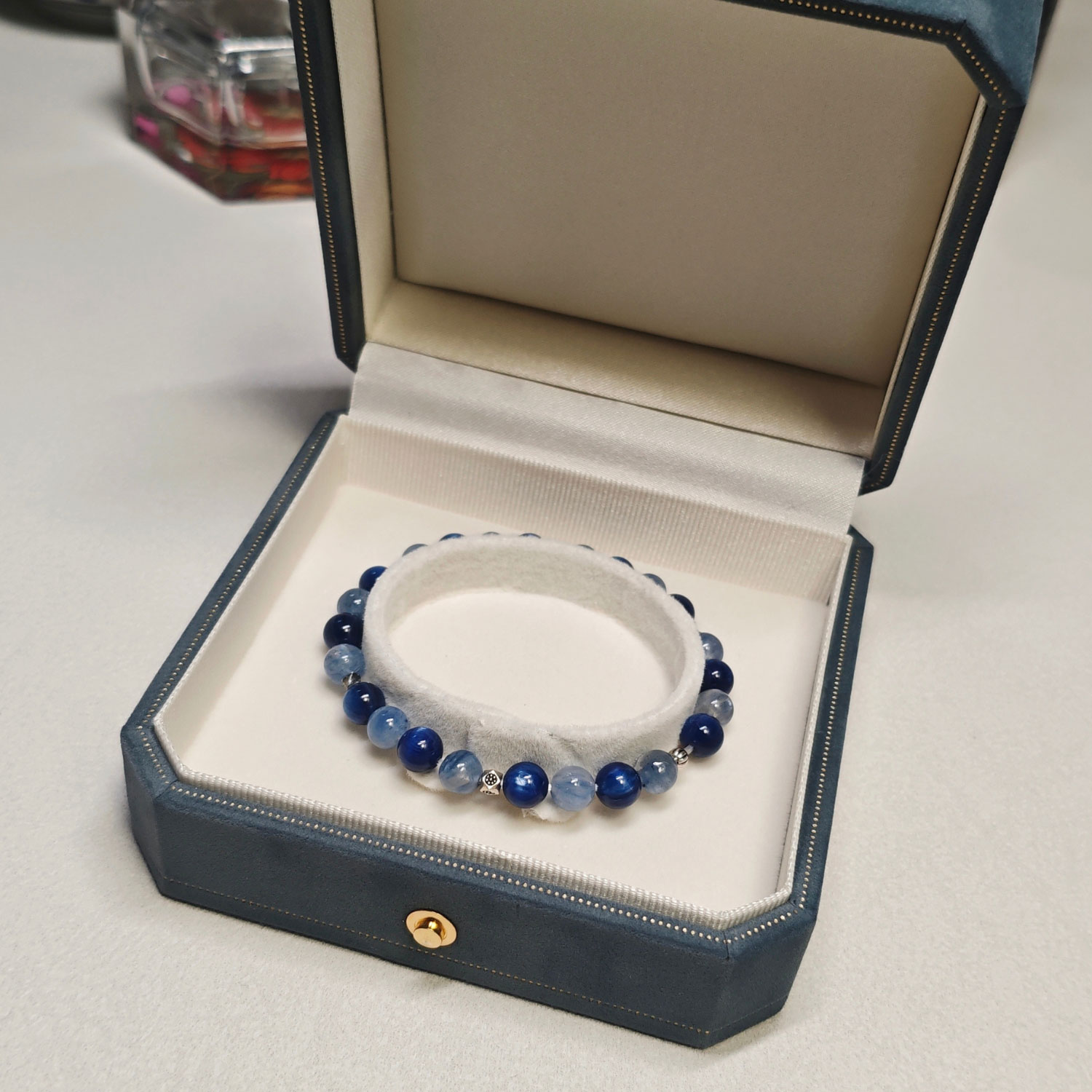 Still blue crystal bracelet resting on the cushion of an open blue gift box