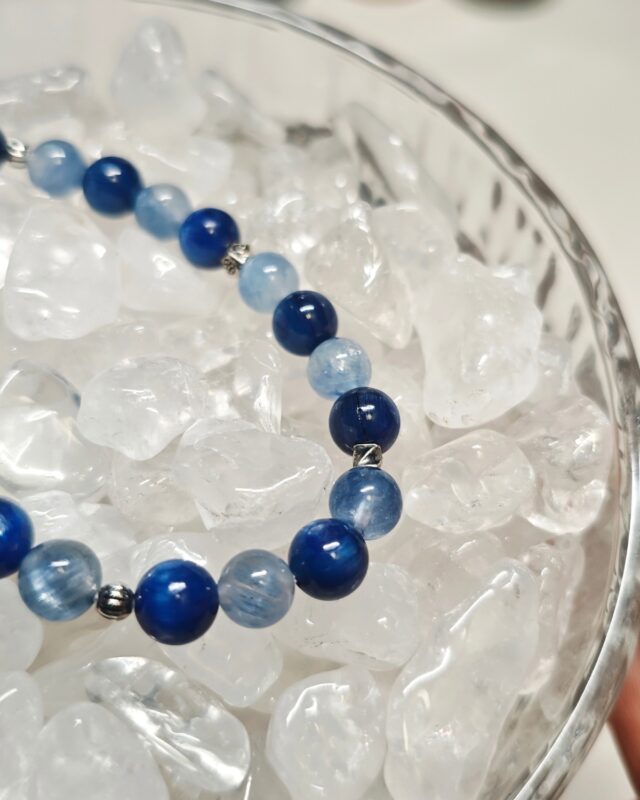Close detail of blue kyanite beads beside sterling silver spacer beads on the still blue crystal bracelet