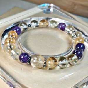 Bracelet on a clear acrylic display stand, golden rutilated quartz and amethyst beads in view