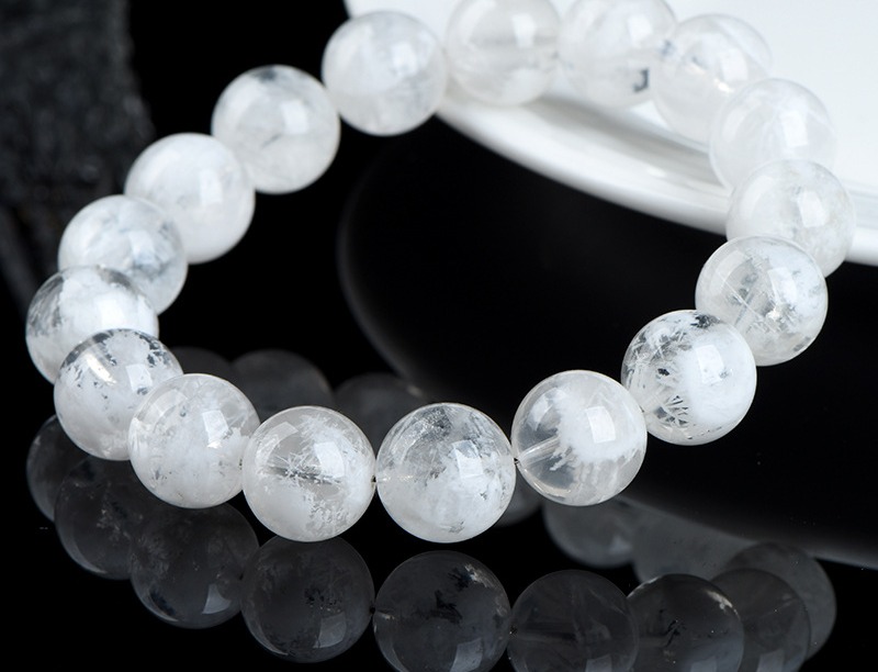 White phantom quartz bead bracelet with milky ghost inclusions, photographed on a black background